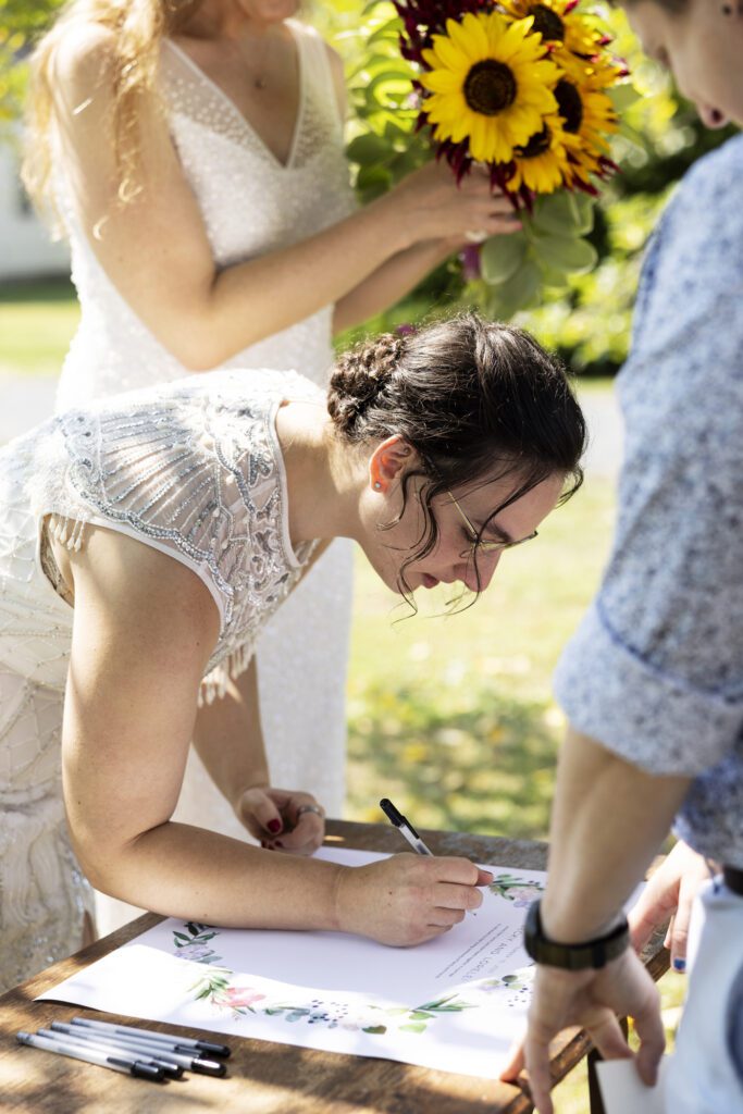 A newly married couple signs a piece of art to commemorate their wedding day in Deerfield, Massachusetts