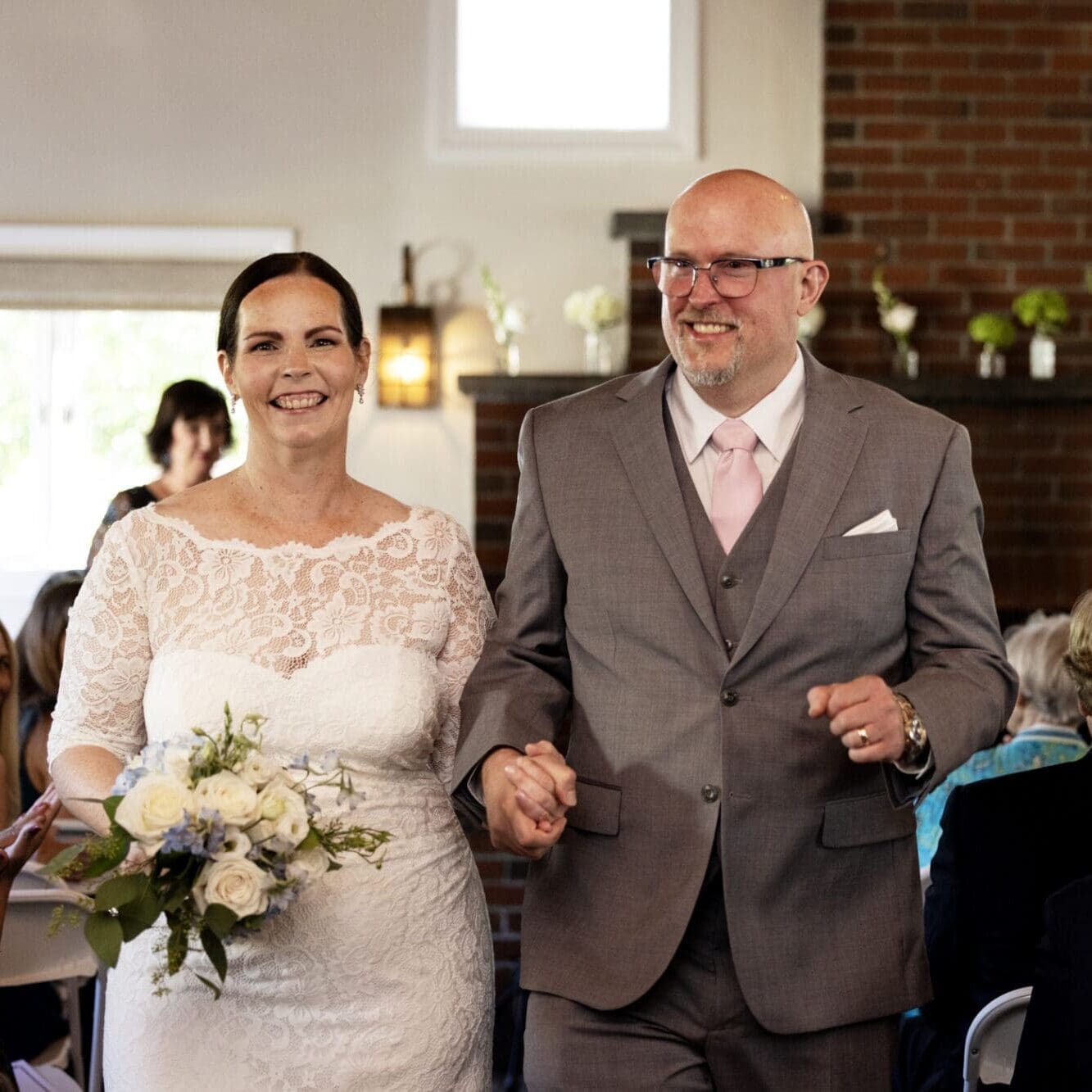 A newly married happy couple smiles as they walk down the aisle after their wedding in Westwood, Massachusetts