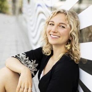 A senior girl smiles during her urban photo session in the Seaport district of Boston, Massachusetts