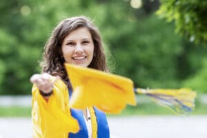 A graduating senior in her gown tosses her cap toward the camera in Littleton, Massachusetts
